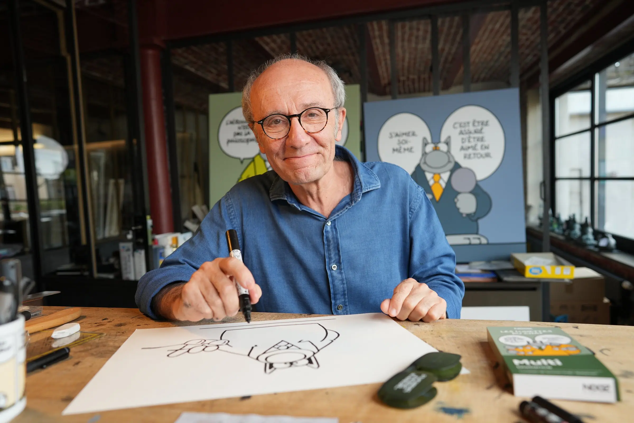 Philippe Geluck zeichnet Le Chat in seinem Atelier